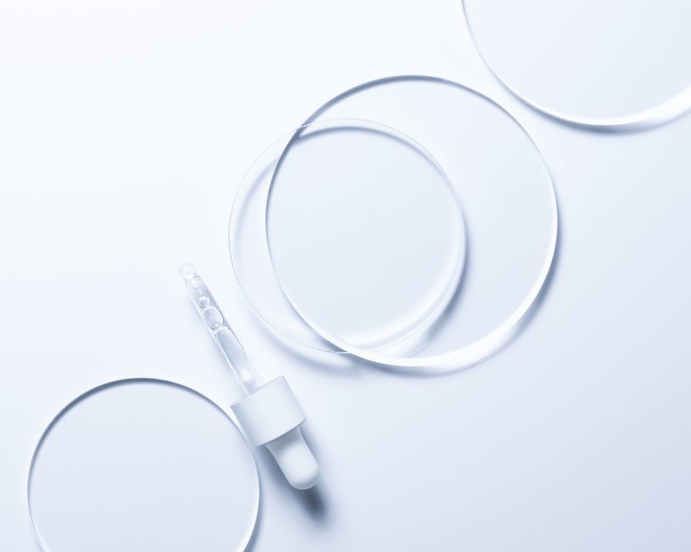 Glass circles on a blue background. A template for placing samples of cosmetics or medical products or food